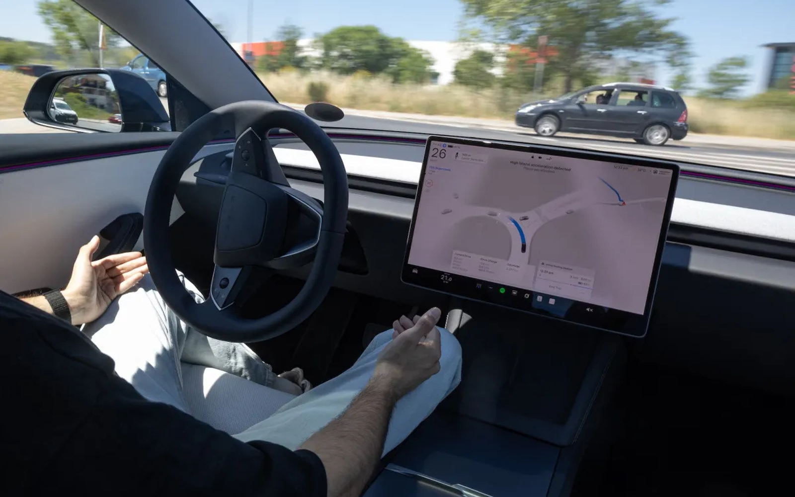 Водач управлява електрически автомобил Tesla с визуализиран интерфейс на софтуера Full Self-Driving